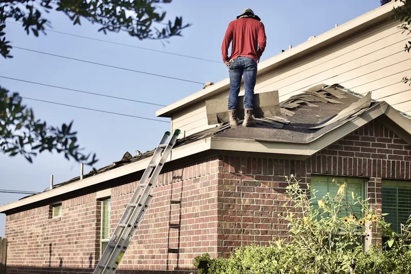 Professional roofer working on a residential roof in Piqua